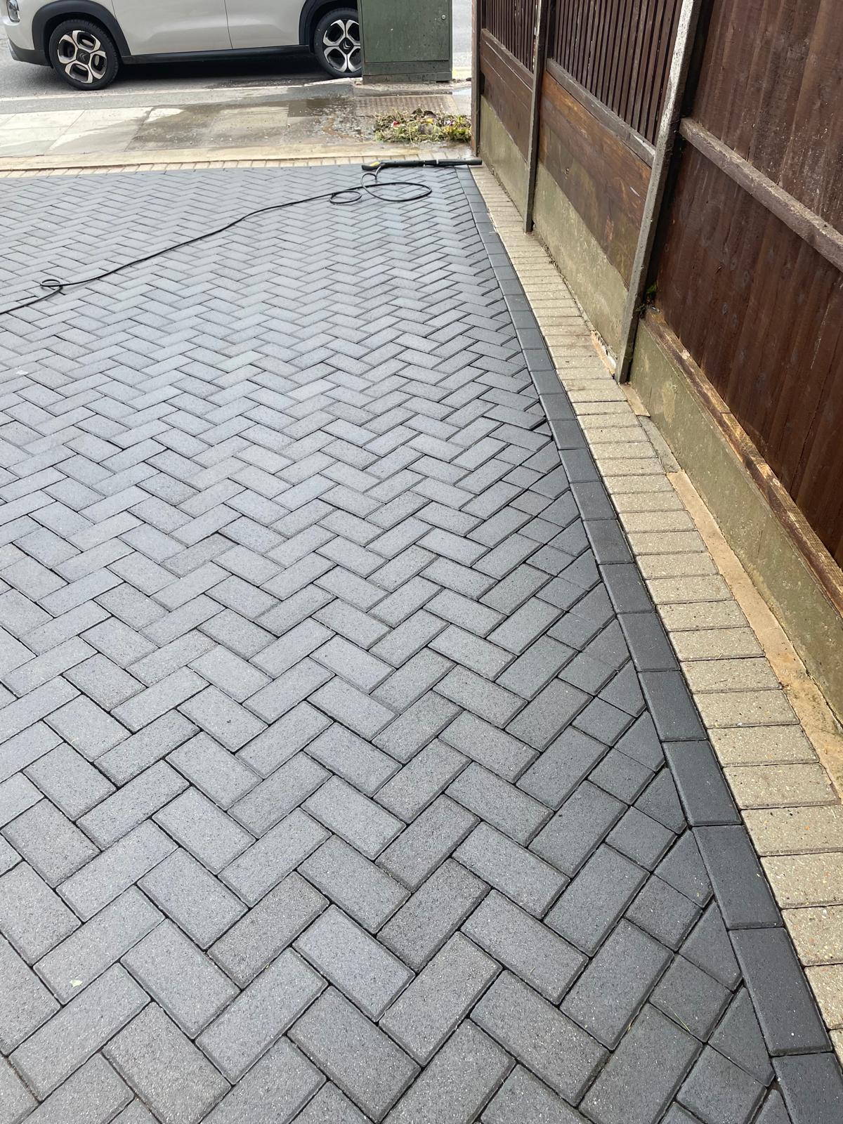 Grey herringbone block paving driveway freshly cleaned