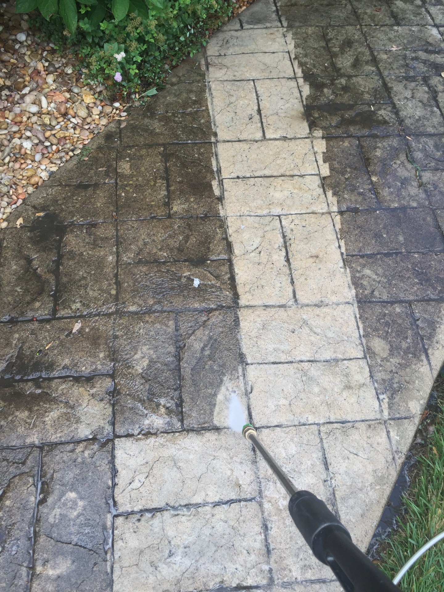 Stamped concrete path mid-clean showing before and after