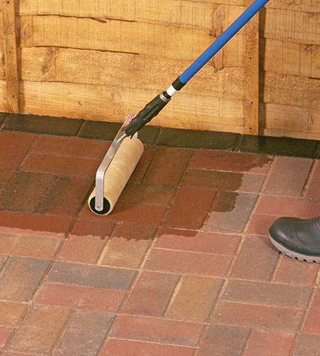 Sealant being applied to a block paving driveway with a roller